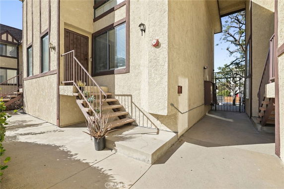 Front view of a house with stairs leading to the entrance.