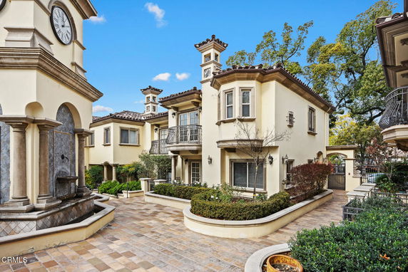 Front view of a two-story house with balconies and decorative columns.