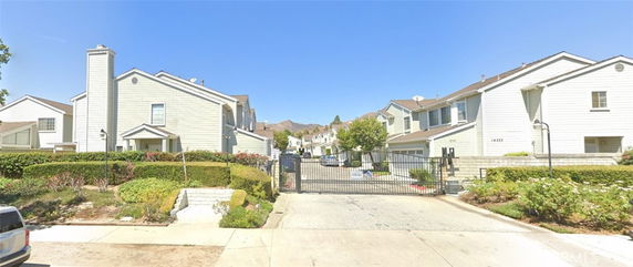 Front view of a gated residential area with multiple two-story houses.