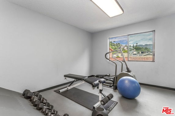 Indoor gym area with exercise equipment and a view from the window.