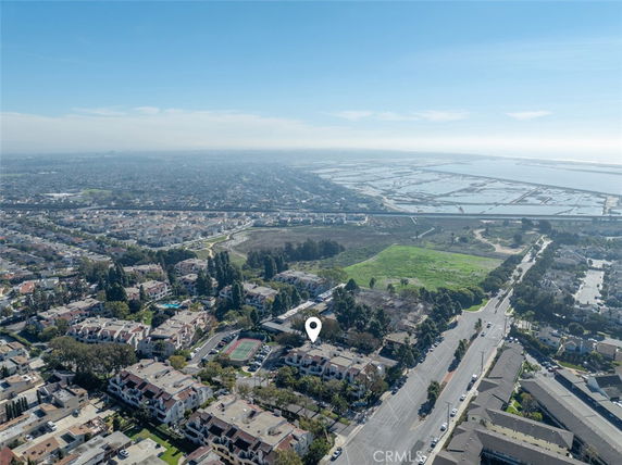 Panoramic view of a cityscape with residential buildings, roads, and a distant body of water.