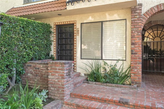 Front view of a house with a brick entryway and a black door.