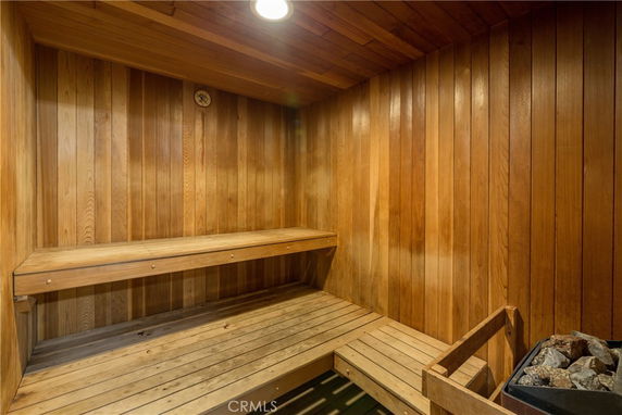 Interior of a wooden sauna room with seating and a heater.