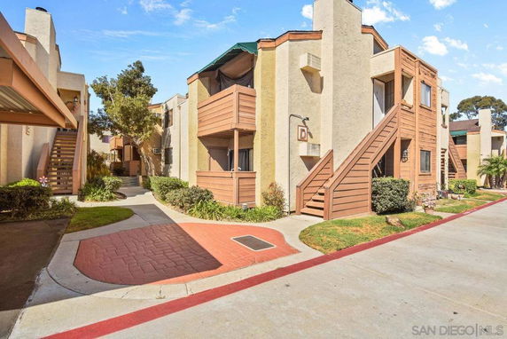 Front view of an apartment building with exterior stairs and balconies.