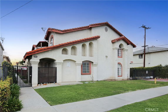 Front view of a two-story house with arches and a red-tiled roof.