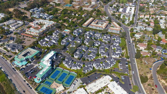 Aerial view of residential buildings with roads and tennis courts.