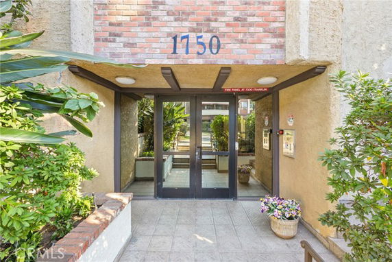 Front entrance of a building with glass doors and brick accents.
