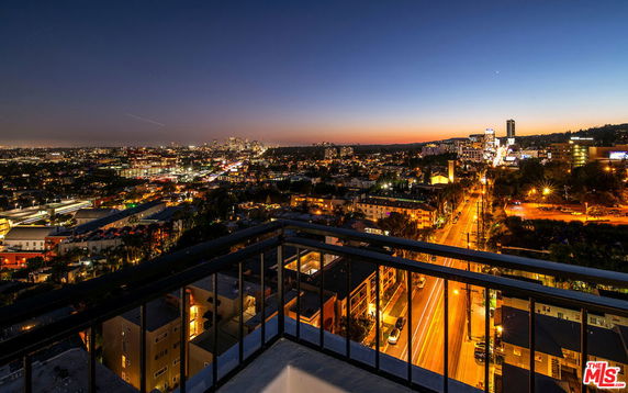 Panoramic view from a high-rise building overlooking a cityscape at dusk.