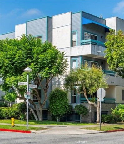 Front view of a multi-story building with modern architecture and balconies.