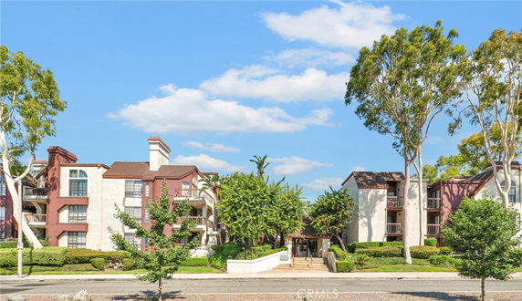 Front view of a multi-story apartment building with balconies and chimneys.