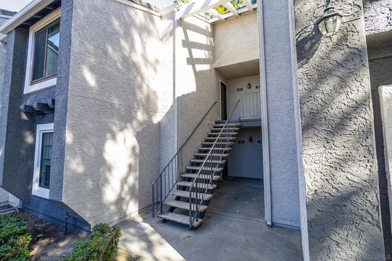 Front view of a two-story building with stairs leading to upper floor entrances.