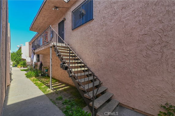 View of an apartment building with exterior stairs leading to the upper level.
