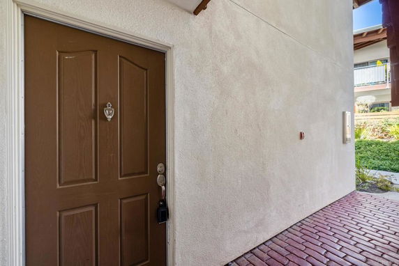 Entrance view with a brown front door and brick walkway.