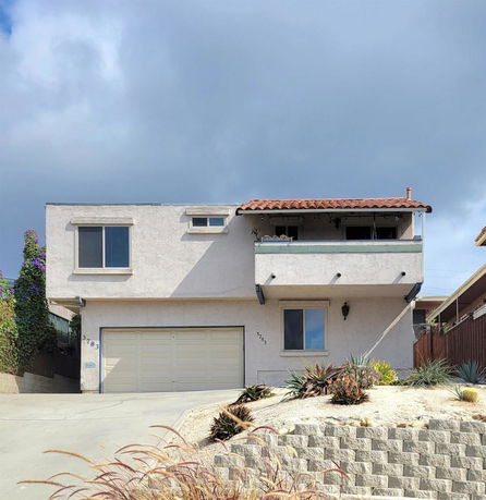 Front view of a two-story house with a double garage and a small balcony.