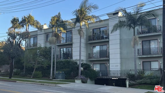 Front view of a multi-story apartment building with balconies.