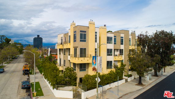 Front view of a multi-story residential building with balconies.