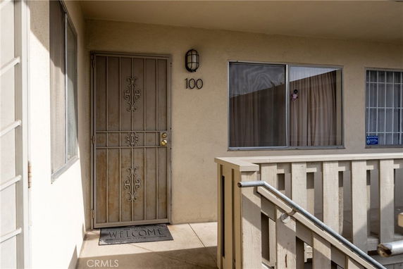 Entrance view of a building with a metal security door and a window.