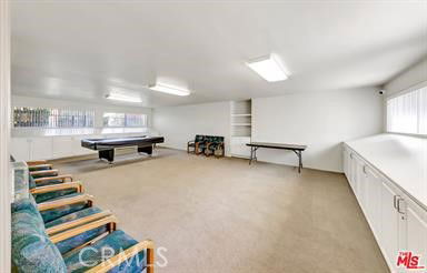 Room with billiards table, chairs, and cabinets.
