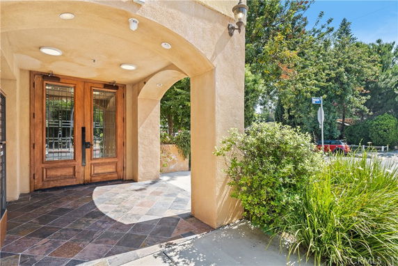 Entrance of a building with wooden double doors and tiled floor.