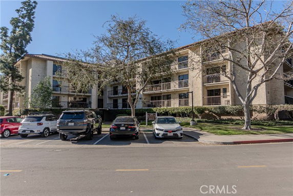 Front view of a multi-story apartment building with balconies.
