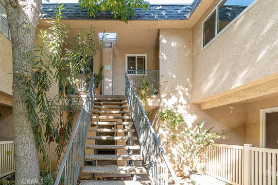 Front view of a two-story residential building with an exterior staircase.