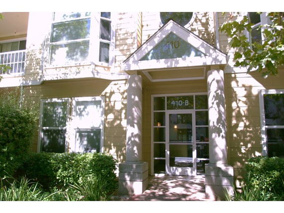 Front view of a building entrance with a glass door and large windows.