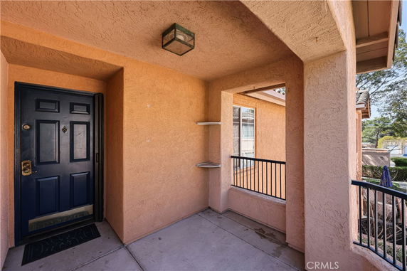 Front view of an entryway with a dark door and beige walls.