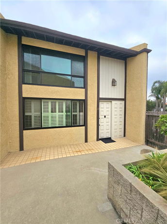Front view of a two-story house with large windows and a double-door entrance.