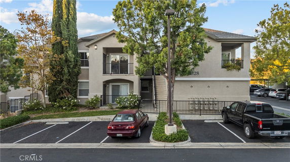 Front view of a two-story residential building with a central staircase and balcony.