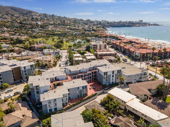 Aerial view of a coastal residential area with apartments and nearby beach.