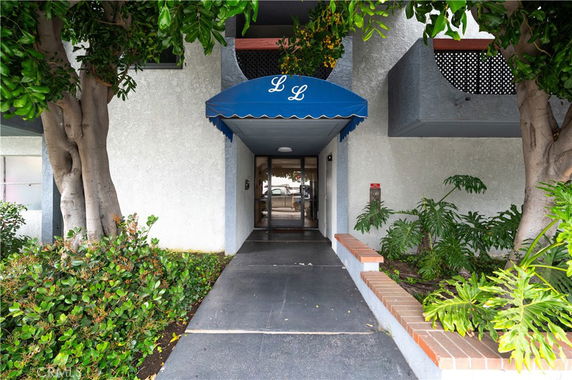 Front view of a building entrance with blue awning.