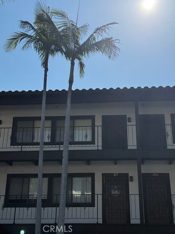 Front view of a two-story building with balconies and doors.