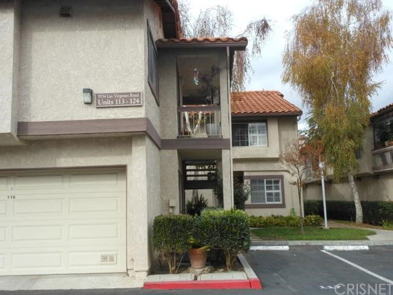 Front view of a two-story residential building with a garage and balcony.