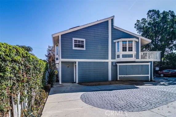 Front view of a two-story house with blue siding and a balcony.