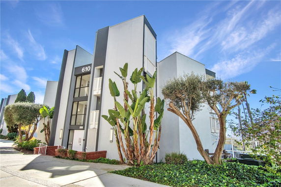 Front view of a modern multi-story building with minimalist design and large windows.