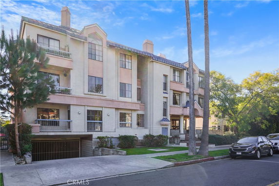 Front view of a multi-story residential building with a parking entrance.