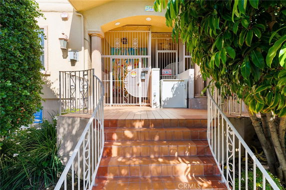 Front view of a house entrance with steps and a gated door.