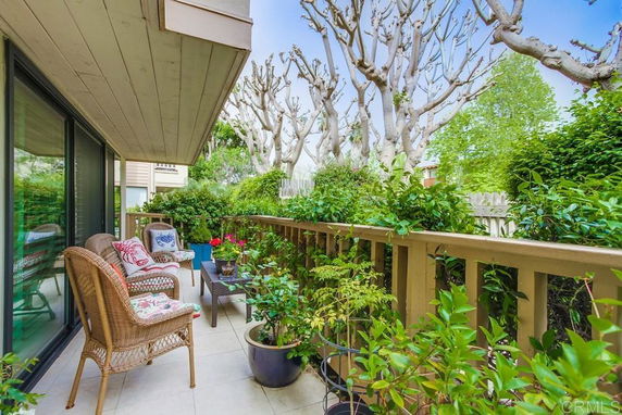 Outdoor balcony with seating and plants.