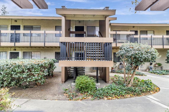 Front view of a two-story apartment building with exterior walkways and staircases.