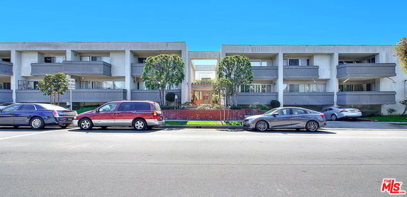 Front view of a multi-story apartment building with balconies.