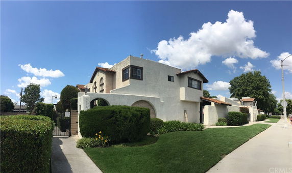 Front view of a two-story house with a white facade and brown roof.