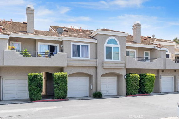 Front view of a two-story residential building with balconies and garages.