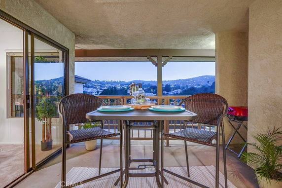 Outdoor area with a table and chairs overlooking the surroundings.