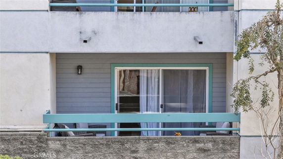 Front view of a building balcony with sliding glass doors and light fixture.