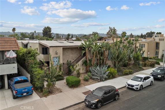 Front view of a single-story building with a flat roof and desert landscaping.