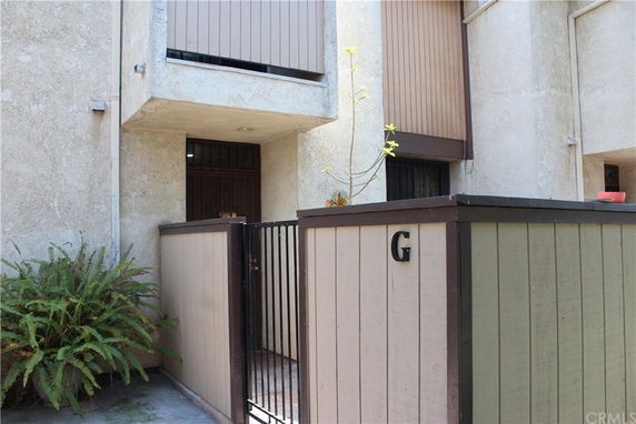 Front view of a multi-story building with a gated entrance marked 'G'.