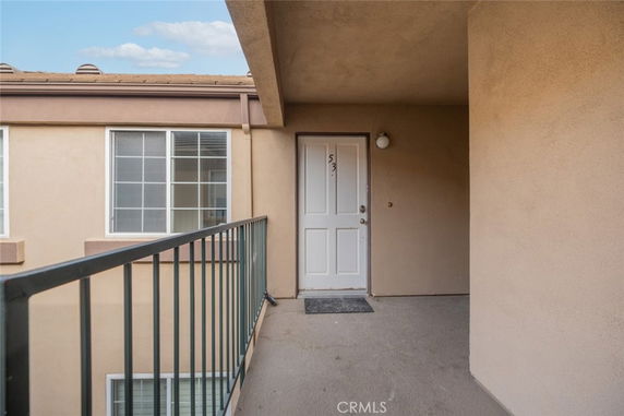 Entryway of a building with a white door and railing.