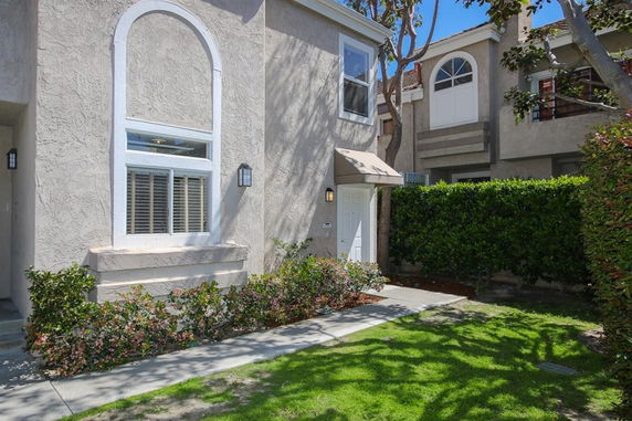 Front view of a two-story house with white trim and arched window details.