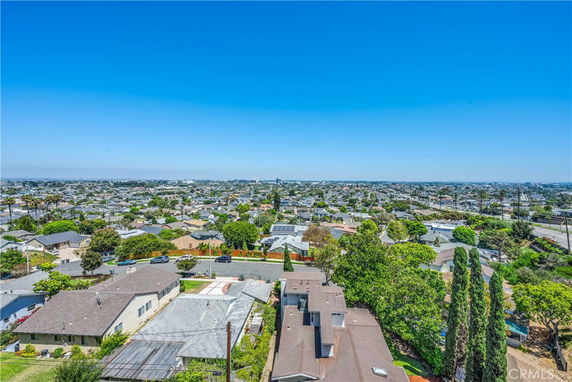 Panoramic view of a residential neighborhood with houses and trees under a clear blue sky.