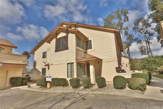 Front view of a two-story house with a gabled roof and beige siding.